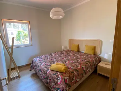 a bedroom with a bed with a yellow pillow on it at Peter Terrace - Rio Douro & Caves Vinho do Porto in Bandeira