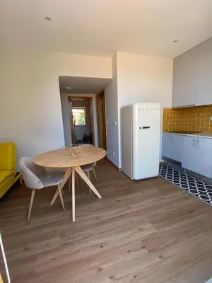 a kitchen with a table and a refrigerator at Peter Terrace - Rio Douro & Caves Vinho do Porto in Bandeira