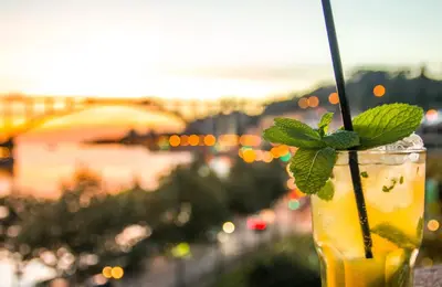 a drink with a mint leaf on top of a balcony at Vincci Porto in Porto