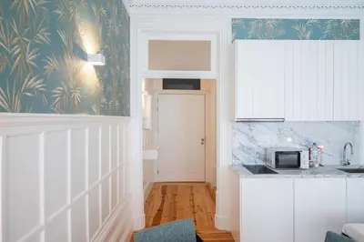 a kitchen with white cabinets and a microwave at HM Loios charming loft in Porto