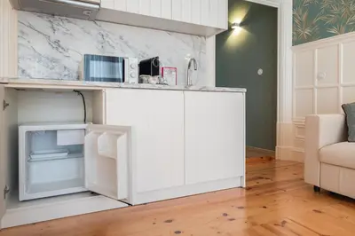 a kitchen with white cabinets and a microwave at HM Loios charming loft in Porto