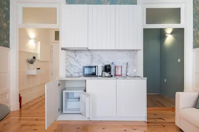 a kitchen with white cabinets and a counter top at HM Loios charming loft in Porto