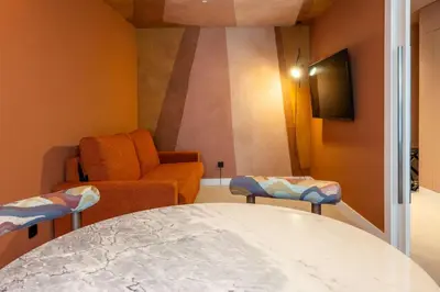 a living room with a table and a chair at Cenica Porto Hotel, Curio Collection By Hilton in Porto