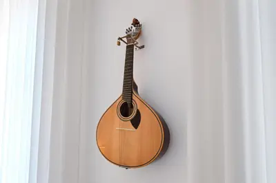 a wooden guitar is hanging on a wall at Almada e Fado in Porto