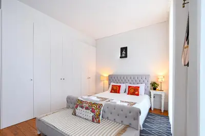a bedroom with a bed and a couch at Almada e Fado in Porto