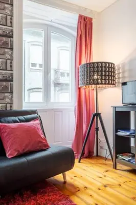 a living room with a couch and a window at Almada e Fado in Porto