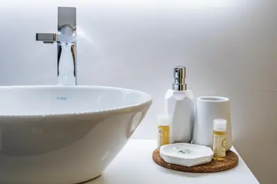 a bathroom counter with a sink and some soap and cosmetics at Cedofeita Bliss - 1BDR with AC in Porto