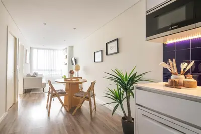 a kitchen and dining room with a table and chairs at Cedofeita Bliss - 1BDR with AC in Porto