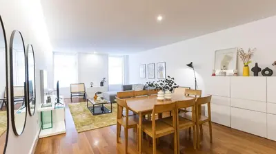 a kitchen and living room with a table and chairs at Fábrica Three-Story Charm by LovelyStay in Porto