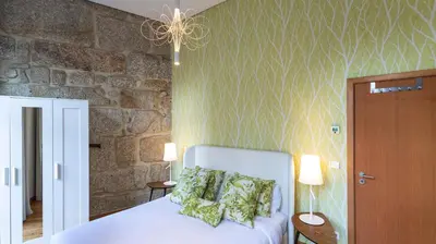 a bedroom with a bed and a stone wall at Mouzinho's Place by LovelyStay in Porto