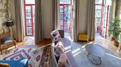 a living room with a couch and some windows at Mouzinho's Place by LovelyStay in Porto