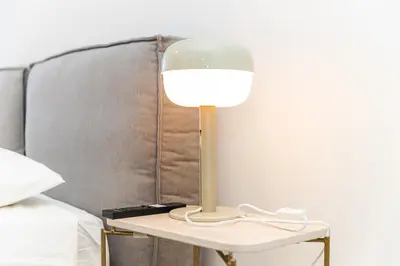 a lamp on a side table next to a bed at Oporto Charming Studio Gaia in Vila Nova de Gaia