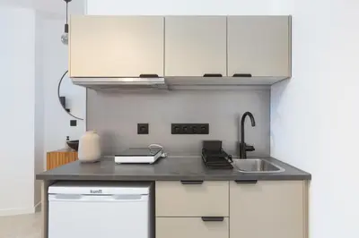 a kitchen with white cabinets and a sink at Oporto Charming Studio Gaia in Vila Nova de Gaia