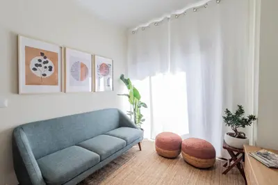 a living room with a blue couch and a television at Apartment in city center in Porto