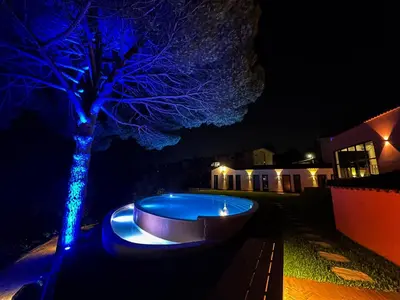 a pool with blue lights in a yard at night at The Lost Garden in Vila Nova de Gaia