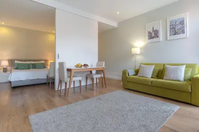 a living room with a couch and a table and a bed at Oporto View Apartments in Porto