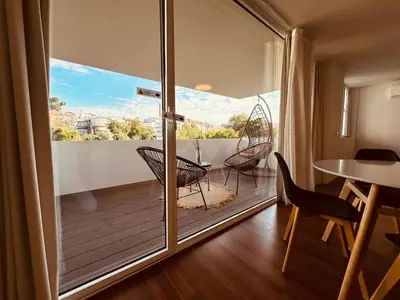 a room with a balcony with chairs and a table at Bombarda H in Porto