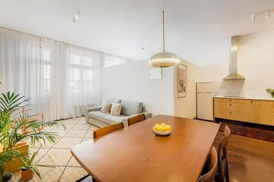 a living room with a wooden table and a couch at Hey Apartments B in Porto