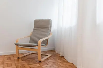 a chair sitting in a room next to a curtain at GuestReady - Hospitality Atrium - Leite Residence in Vila Nova de Gaia