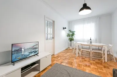 a living room with a television and a dining table at GuestReady - Hospitality Atrium - Leite Residence in Vila Nova de Gaia