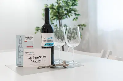 a bottle of wine and two wine glasses on a table at GuestReady - Hospitality Atrium - Leite Residence in Vila Nova de Gaia