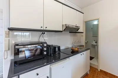 a kitchen with white cabinets and a microwave at Dream Bonfim in Porto