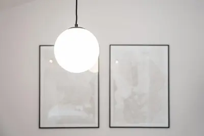 two framed pictures on a wall with a light fixture at GuestReady - Porto's Modern Comfort in Porto