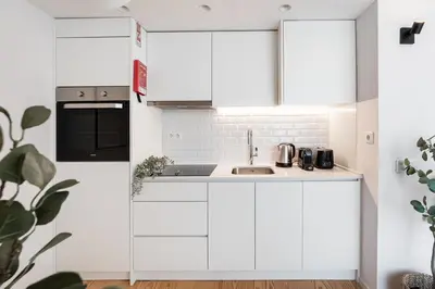 a kitchen with white cabinets and a sink at GuestReady - Porto's Modern Comfort in Porto