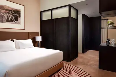 a bedroom with a white bed and a black cabinet at Tivoli Kopke Porto Gaia Hotel in Vila Nova de Gaia