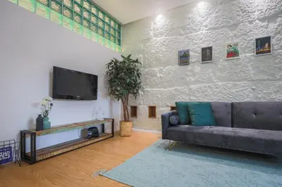 a living room with a couch and a flat screen tv at ApartmentsPorto - Apartamento Belas Artes in Porto
