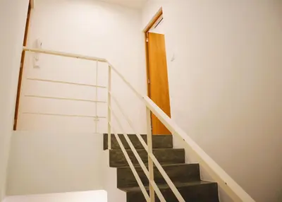 a staircase in a house with white walls and a wooden door at Francos Family House in Porto