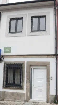 a white building with a white door and two windows at Francos Family House in Porto