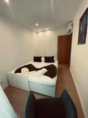 a bedroom with a bed and a chair in it at Francos Family House in Porto