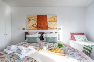 a bedroom with a bed with a tray of food on it at Host Wise - Cozy House w Balcony in Porto