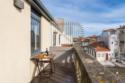 a balcony with a table on the side of a building at Host Wise - Cozy House w Balcony in Porto