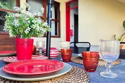a vanity with a mirror and a table with flowers on it at Patio House - 2 Bedroom flat - Pet Friendly in Porto