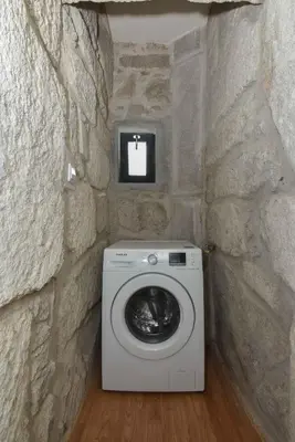 a washer and dryer in a stone wall at Almada Apartments 468 in Porto