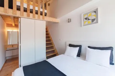 a small bedroom with a bed and a loft conversion at Almada Apartments 468 in Porto