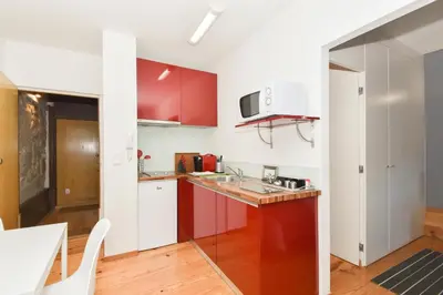 a kitchen with red and white cabinets and a table at Almada Apartments 468 in Porto
