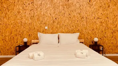 two towels on a bed in front of a stone wall at Raul Dória - Guesthouse in Porto