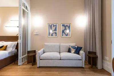 a bedroom with a couch and a bed and a mirror at ApartmentsPorto - Almada 318 in Porto