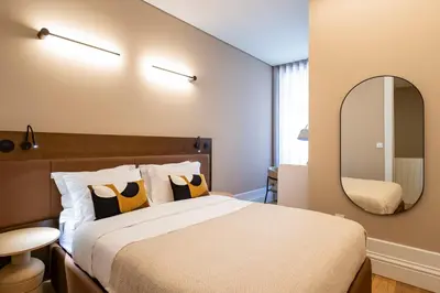 a bedroom with a large bed and a mirror at ApartmentsPorto - Almada 318 in Porto