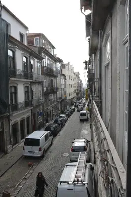 a person walking down a street with parked cars at Oporto Almada 329 in Porto