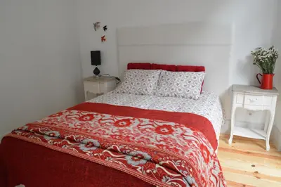 a bedroom with a bed with a red and white comforter at Oporto Almada 329 in Porto