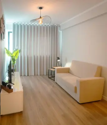 a living room with a white couch and a table at The Cale - Antero de Quental - 12 in Porto