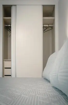 a bedroom with a white bed and a closet at The Cale - Antero de Quental 22 in Porto