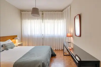 a bedroom with a bed and a large window at Julio Dinis Studio in Porto