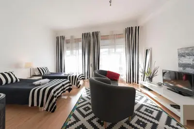 a living room with a bed and a tv at BmyGuest - Santa Catarina's Loft in Porto