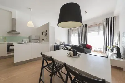 a kitchen and living room with a table and chairs at BmyGuest - Santa Catarina's Loft in Porto