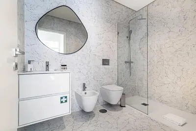 a bathroom with a toilet and a sink and a mirror at Paraíso E in Porto